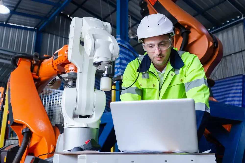 man-engineer-using-laptop-control-robot