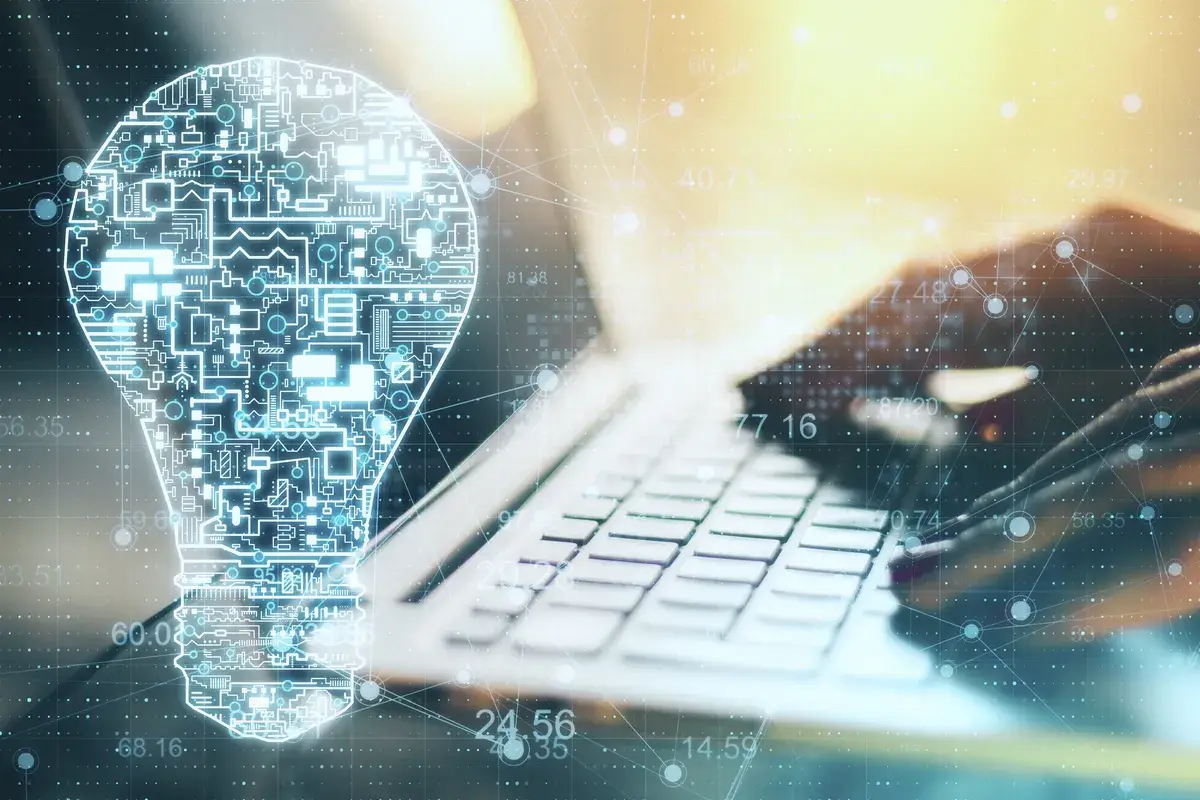 hand-using-laptop-with-glowing-circuit-lightbulb