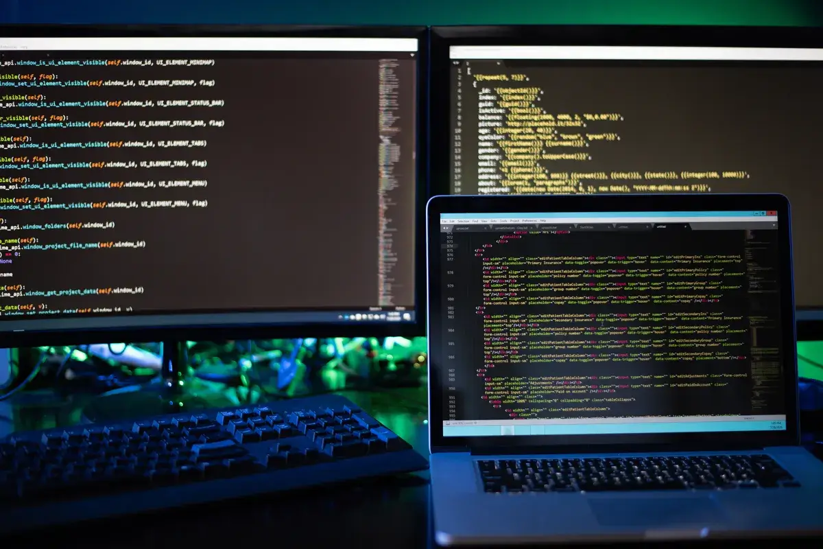 three-computer-screens-with-computer-programming