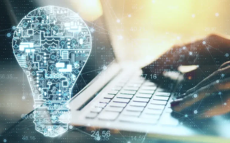 hand-using-laptop-with-glowing-circuit-lightbulb