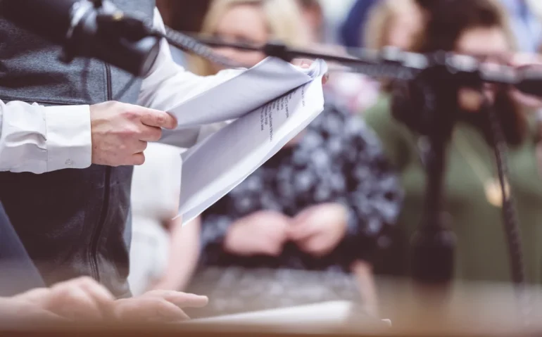 presenter-at-podium-reads-documents